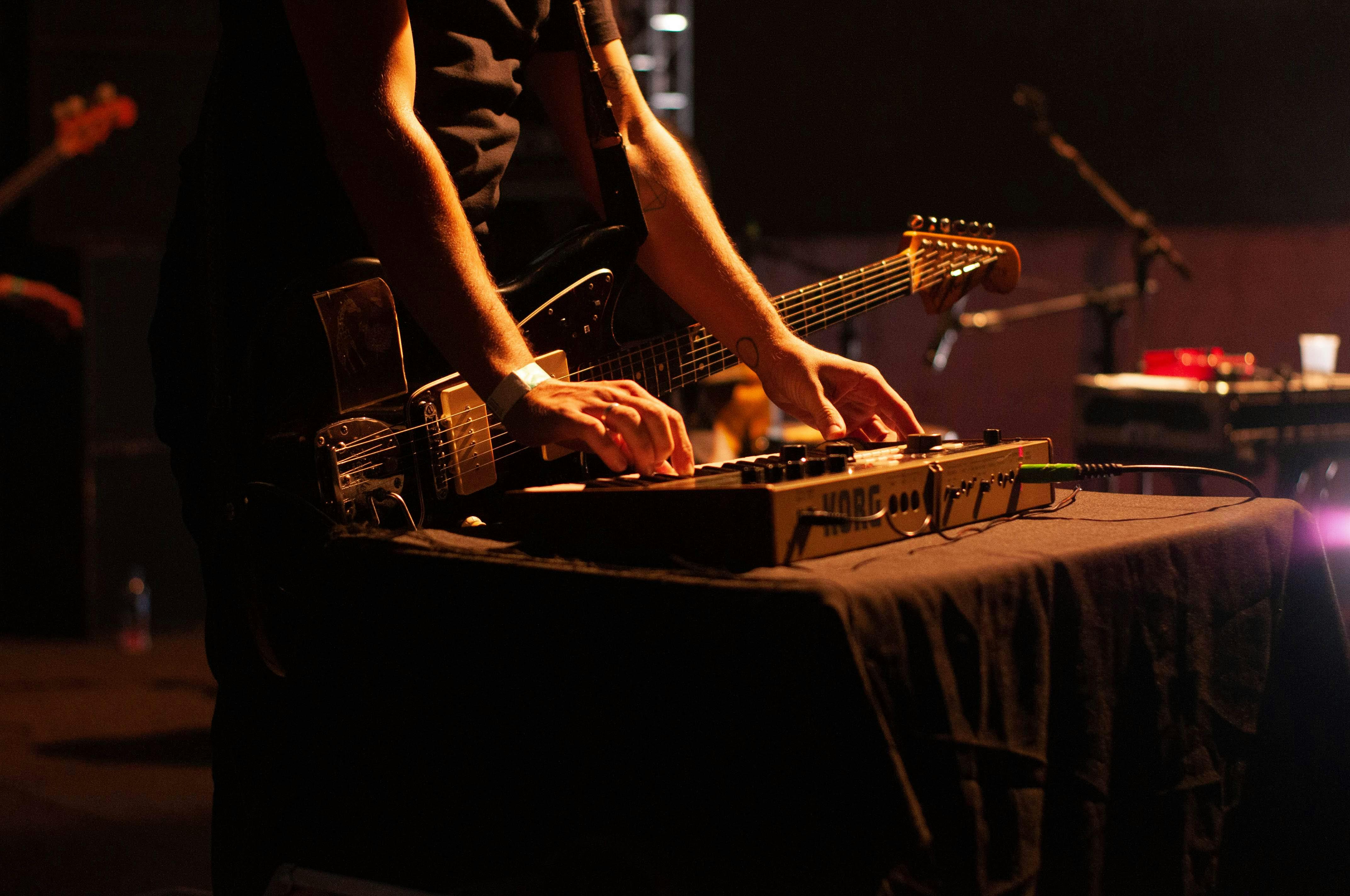crop guitarist playing synthesizer during concert