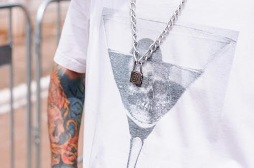 Free Tattooed Person Wearing Silver Necklace with Padlock Pendant  Stock Photo