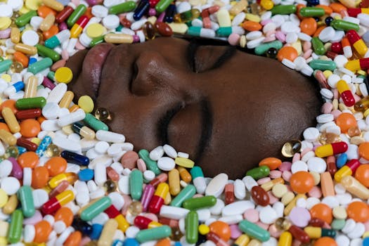 Close-up of an African American face surrounded by a variety of colorful pills, illustrating health and medication themes.