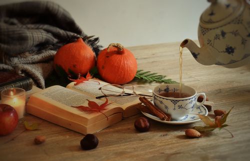 Free Warm autumn ambiance with tea, pumpkins, and books on a wooden table, perfect for cozy moments. Stock Photo