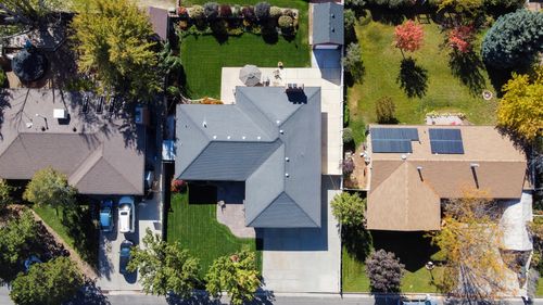 Free Drone shot capturing rooftops, solar panels, and green lawns in South Jordan, Utah. Stock Photo