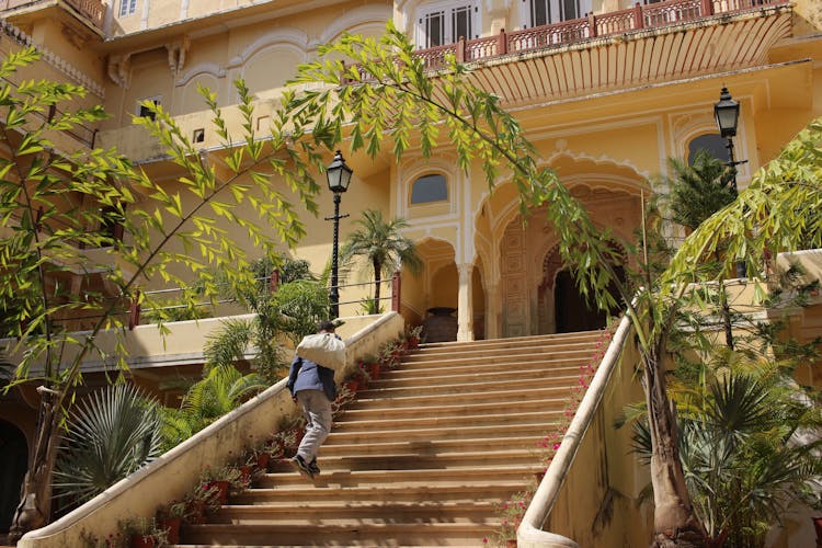 A Man Going Up The Steps Of A Building