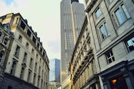 从低角度拍摄，捕捉城市中现代摩天大楼与历史建筑交错的景观