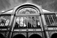 低角度视角下的单色建筑立面，配有华丽的拱形窗户和复杂设计