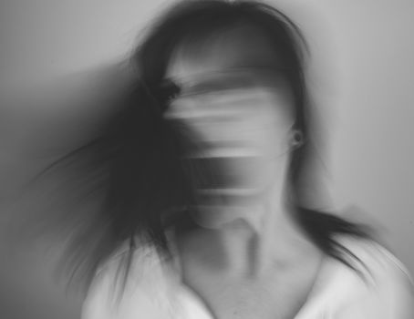 An abstract black and white portrait capturing motion blur of a person in expressive movement.