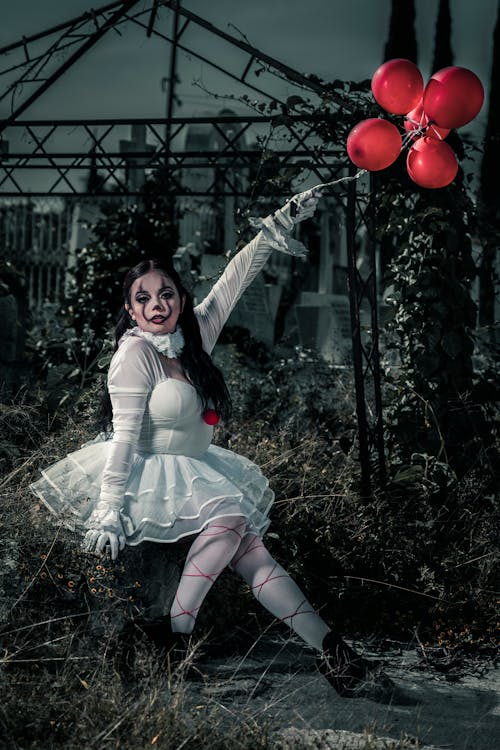 Scary Woman in White Dress Holding Red Balloons 