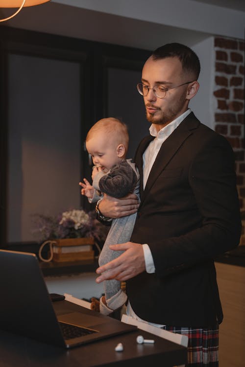 A Man Working from Home while Carrying a Baby