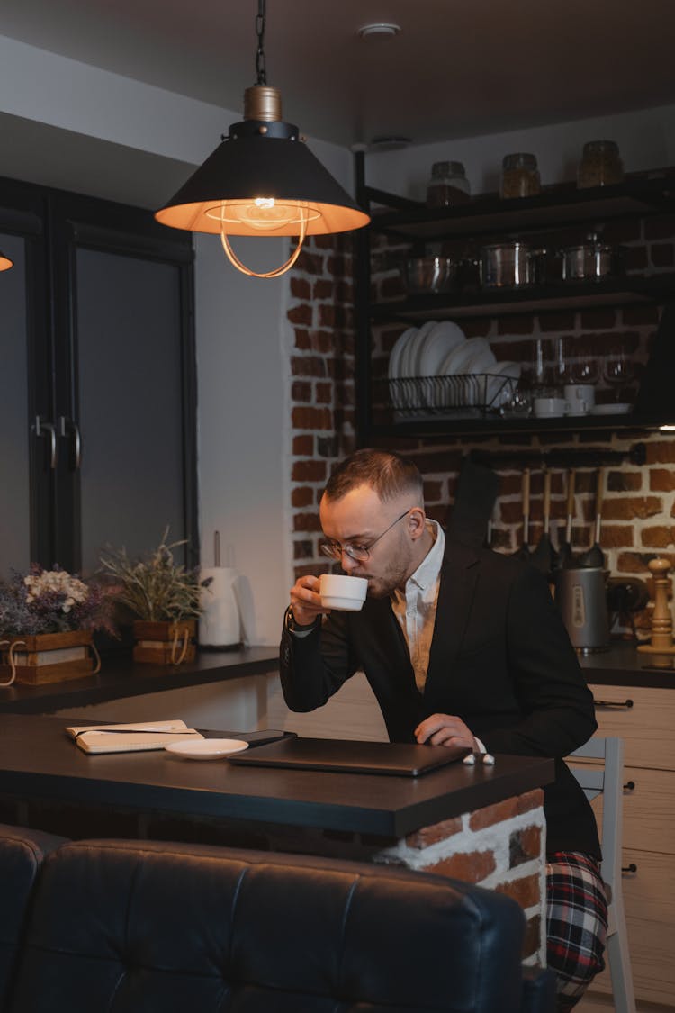 A Man Sipping Coffee While Working From Home