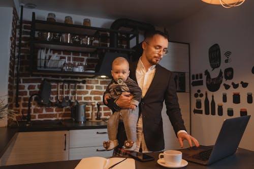 A Man Working from Home while Carrying a Baby