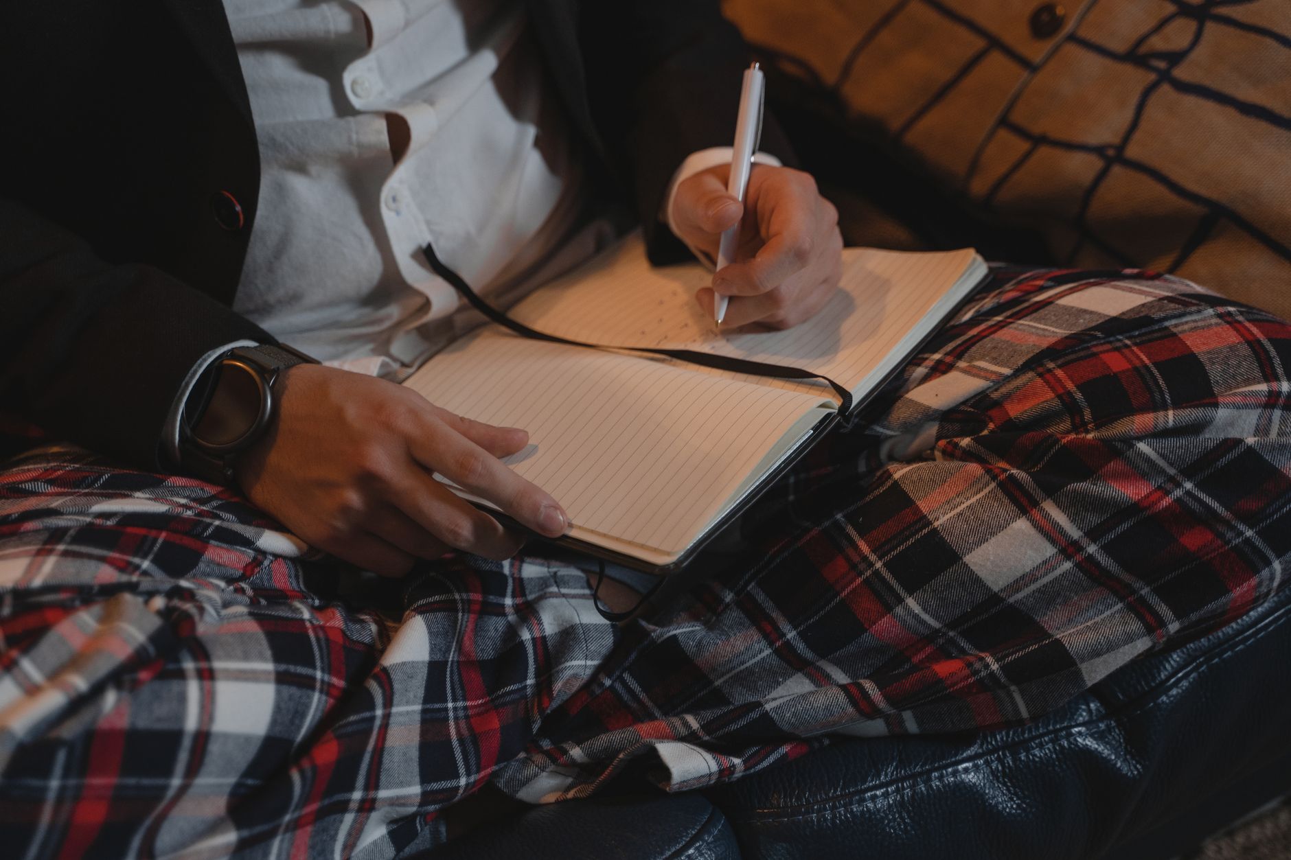 A concerned resident writing time and location details in a notebook beside a quiet roadside at dusk