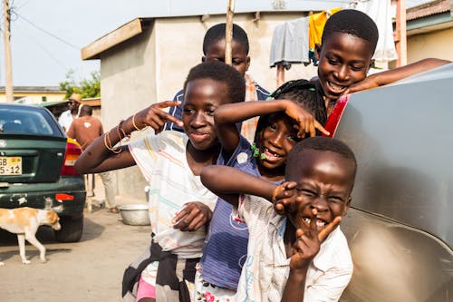 Group of Happy Kids Posing Near the Gray Car 