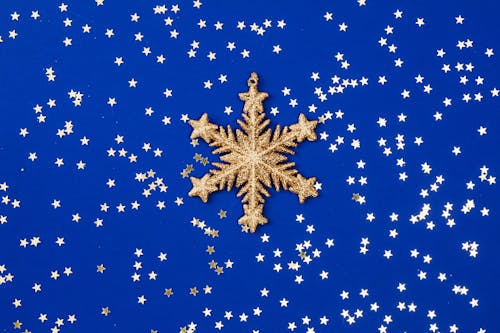 Gold Stars and Gold Snowflake on Blue Background