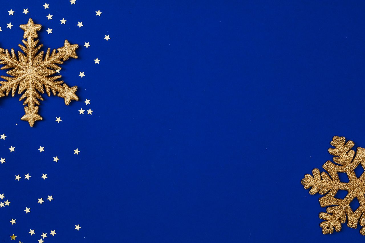 gold glitter snowflakes scattered on a vivid blue backdrop perfect for