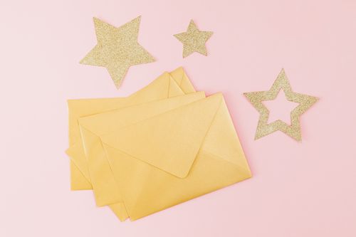 Free Stylish flat lay of golden envelopes and glitter stars on a pink background, perfect for invitations. Stock Photo