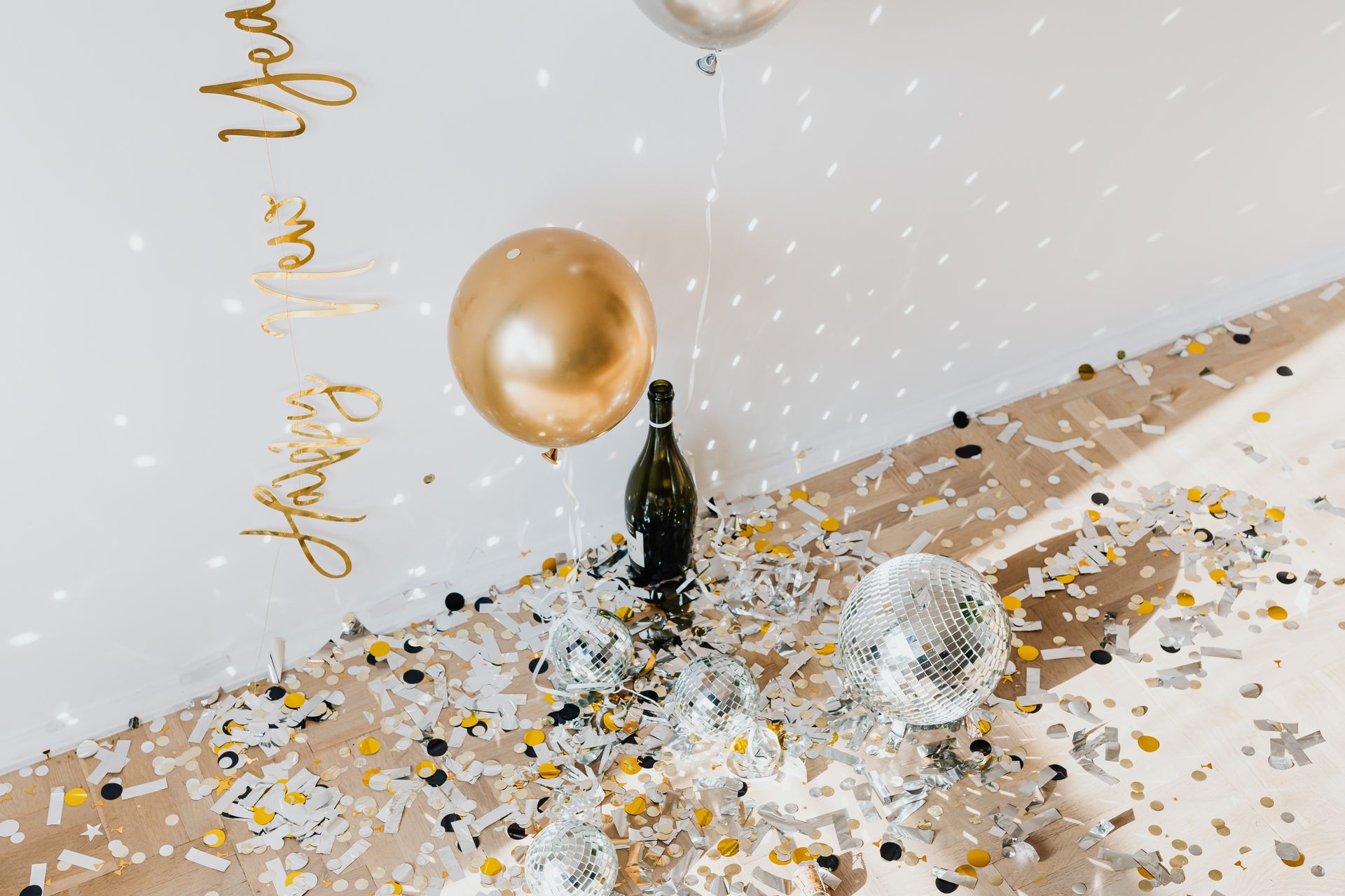 Elegant New Year celebration scene with balloons, champagne, and disco balls.