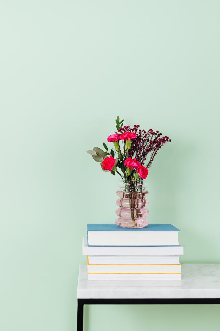 Vase With Flowers On Pile Of Books