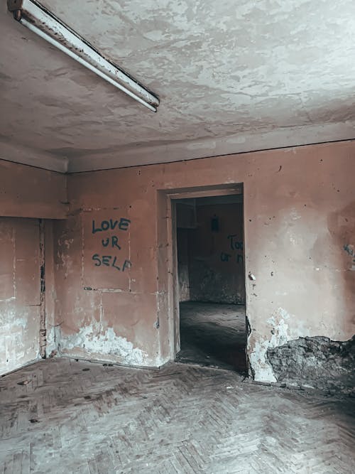 From inside abandoned ruined building room with weathered concrete walls and dirty shabby parquet