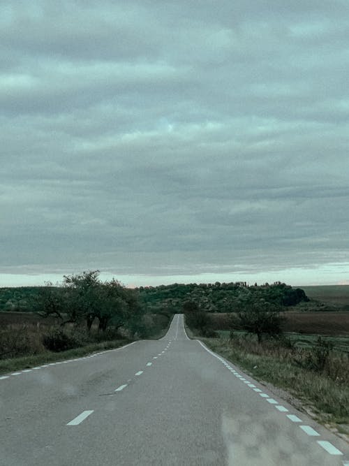 Empty paved road running through fields