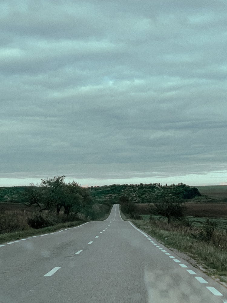 Empty Paved Road Running Through Fields