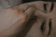 Crop female with closed eyes sinking under water pinching nose with hand and holding breath