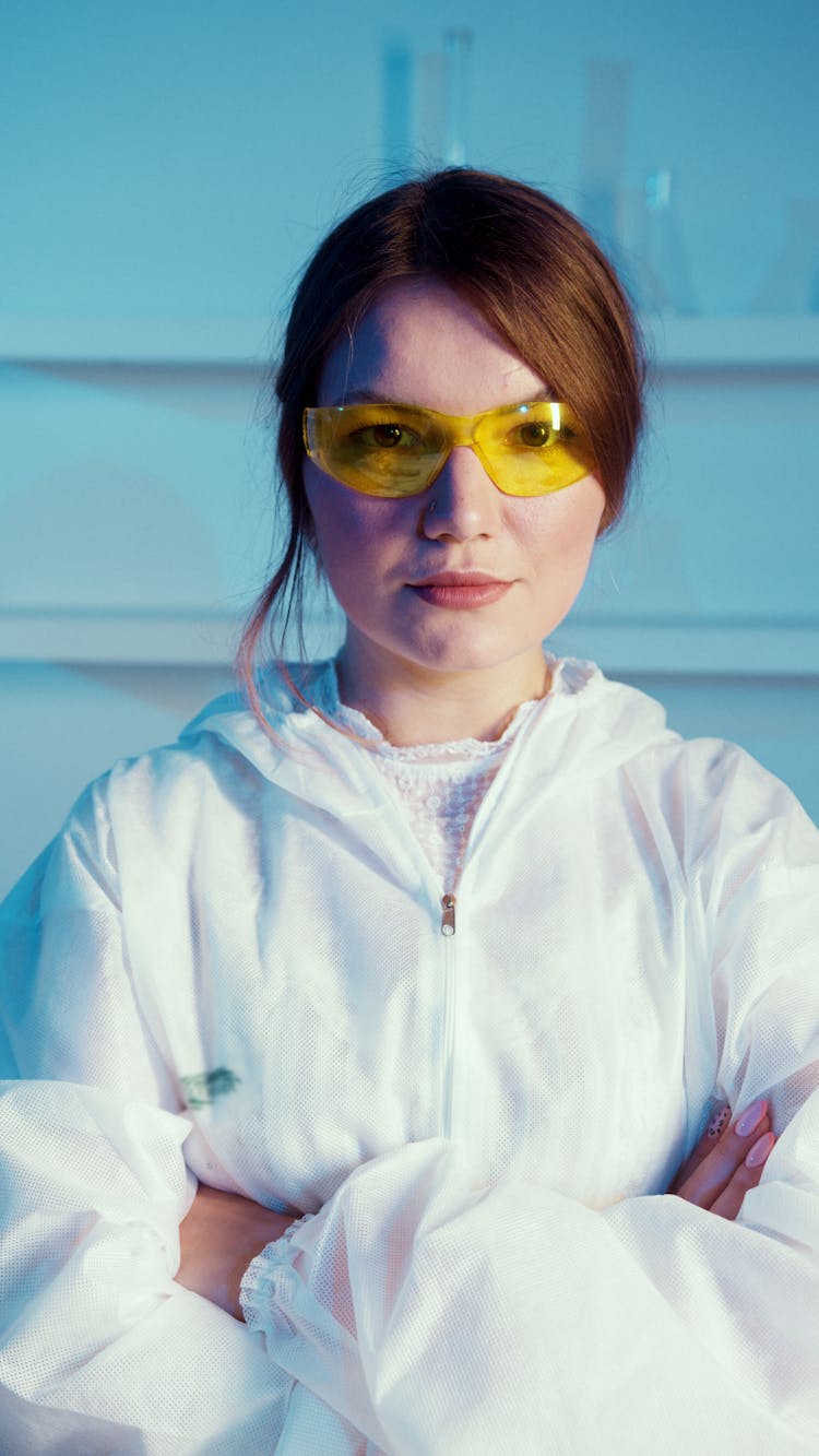 A Woman Wearing A White Lab Coat And Orange Protective Goggles