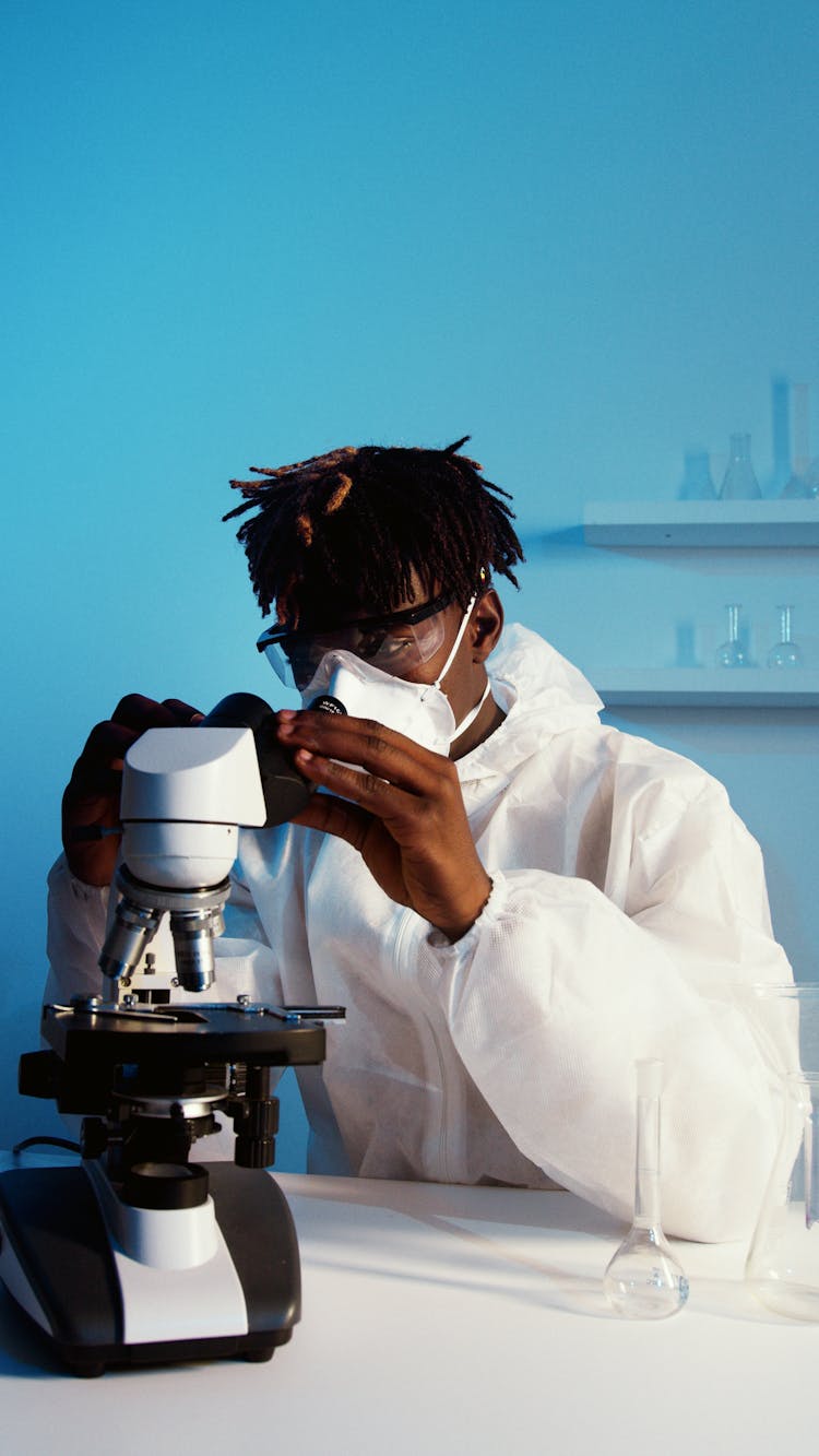 A Man Looking Through The Microscope