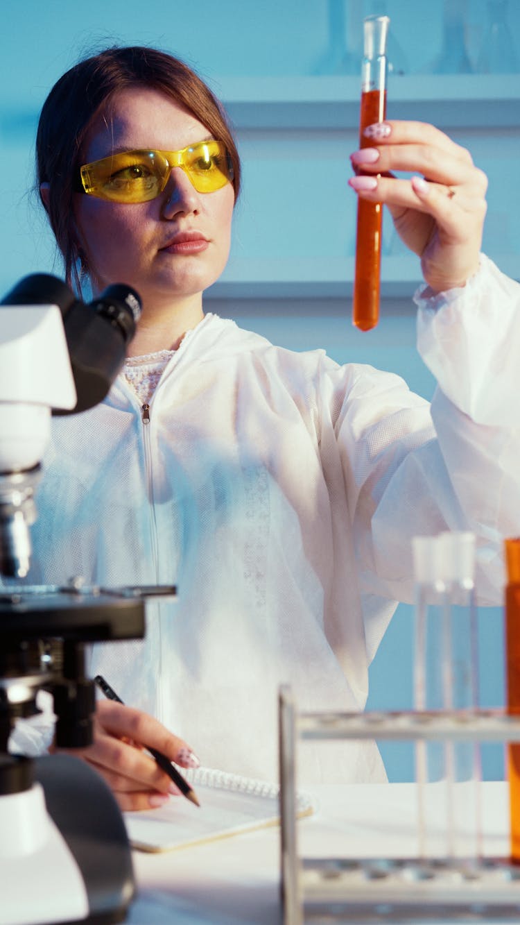 A Woman Holding While Looking At A Test Tube