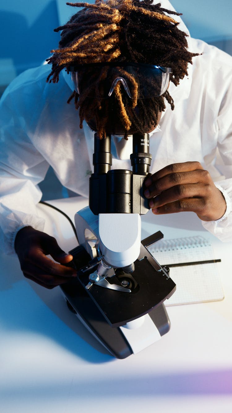 A Man Looking Through The Microscope