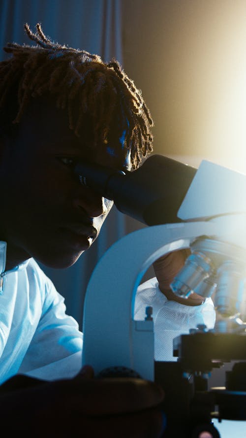 A Man Looking Through the Microscope