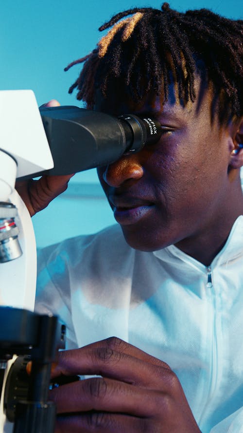 A Man Looking Through the Microscope