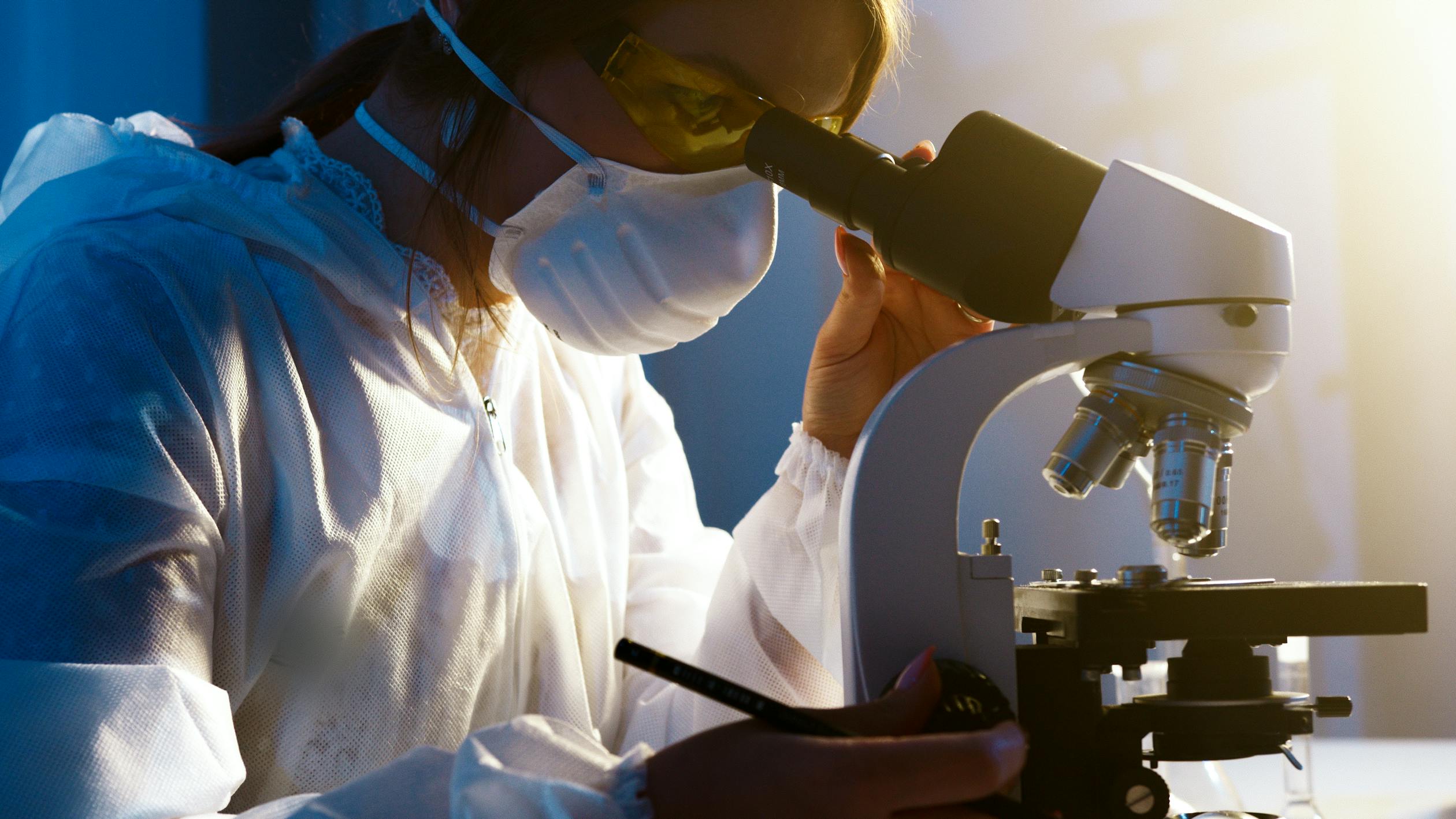 girl looking into microscope