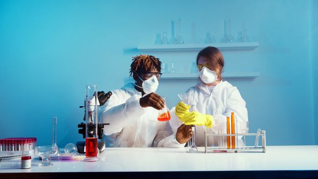 两名科学家穿着实验室外套，在实验室里进行化学实验