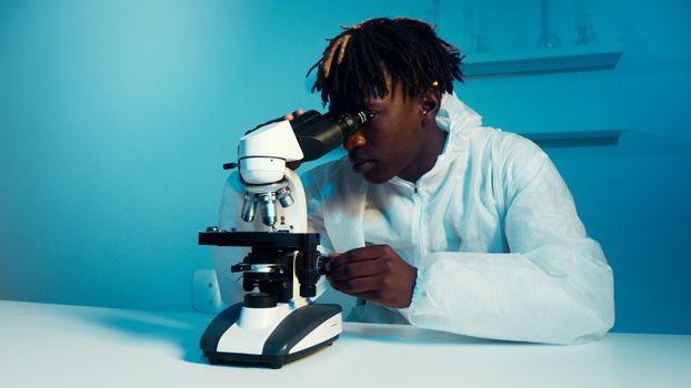 在现代实验室环境中，穿着实验服的科学家正在使用显微镜