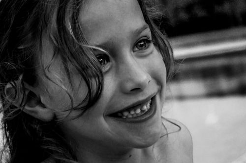 Free Close-up grayscale portrait of a smiling young girl, capturing joyful expression. Stock Photo