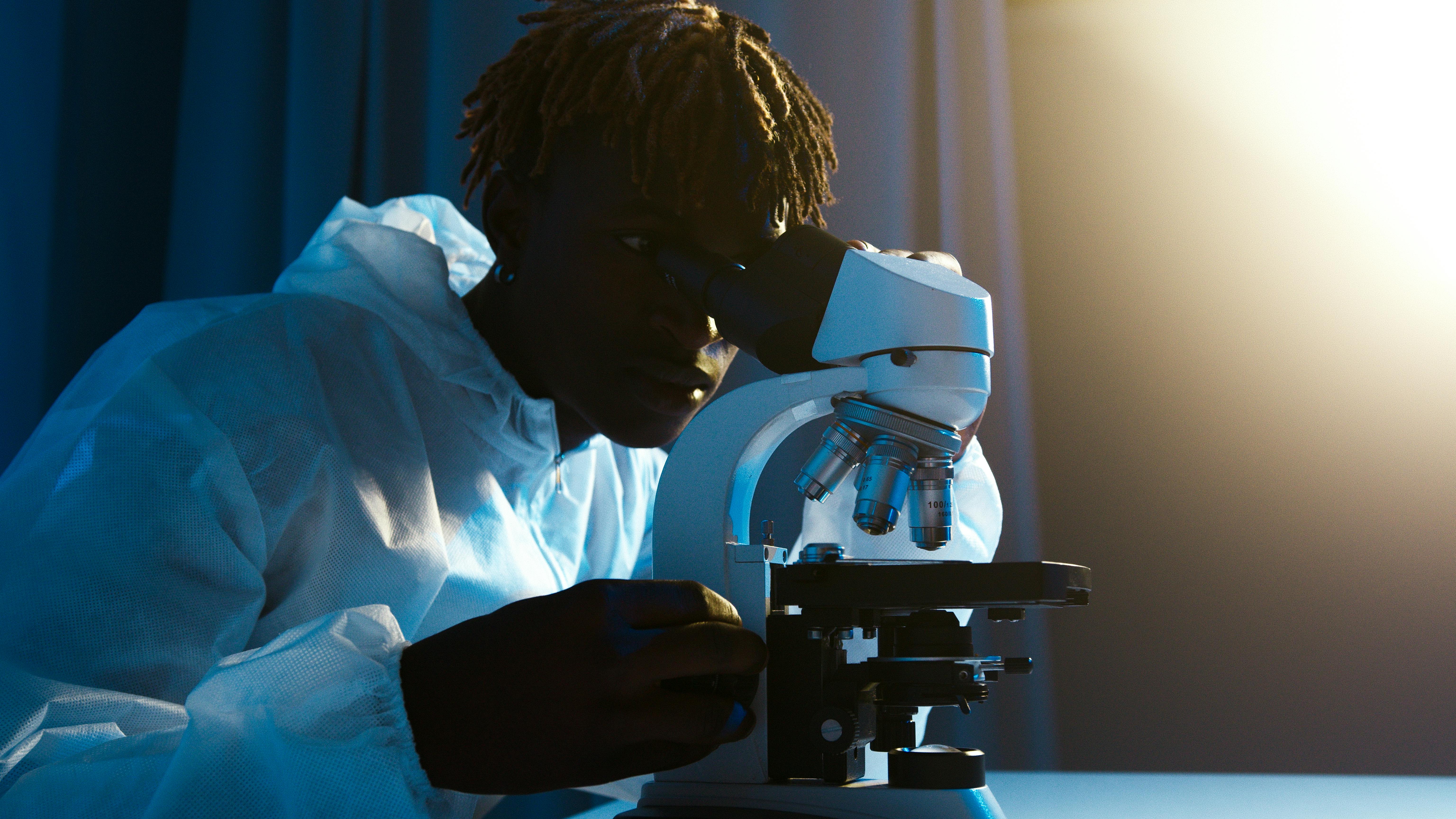 Free A Man Looking Through the Microscope Stock Photo