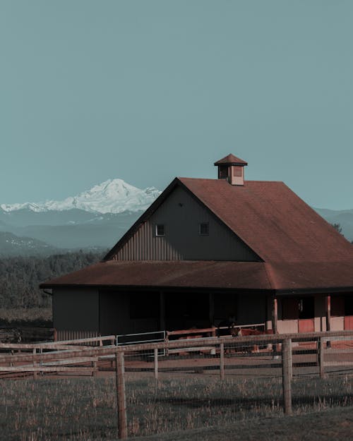 Brown Wooden Farmhouse On Grass Field