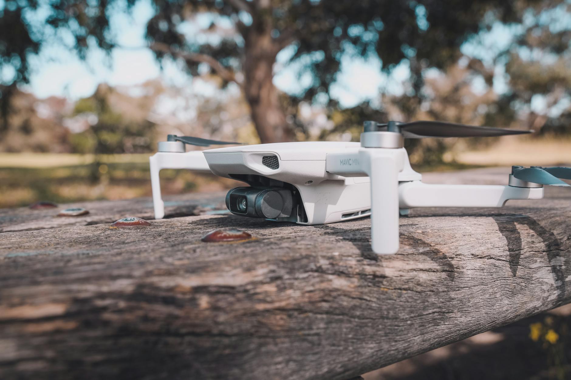 White and Black Drone on Wooden Table