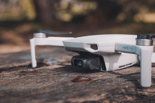 Free White and Black Drone on Wooden Surface Stock Photo