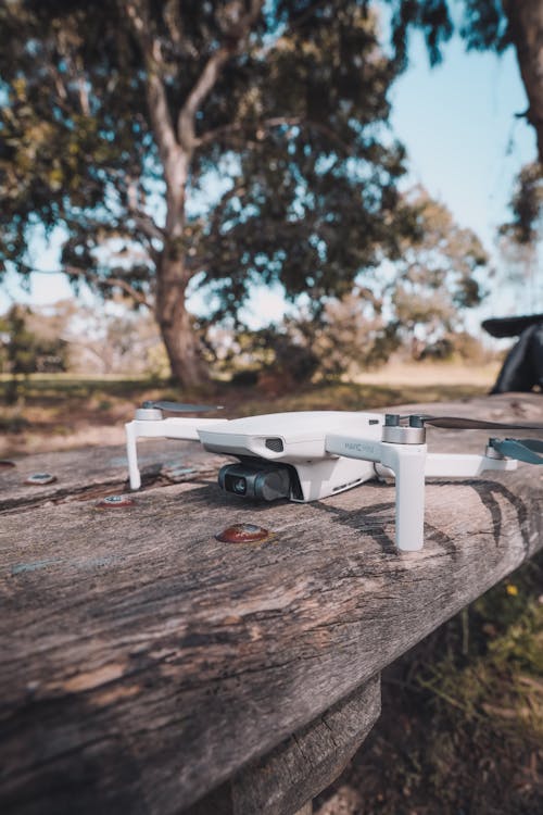 White Drone on Brown Wooden Table