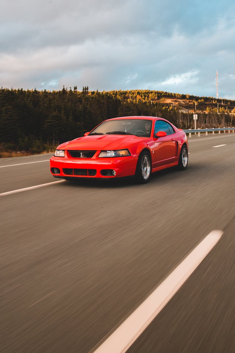 Sports Car Driving Along Asphalt Roadway