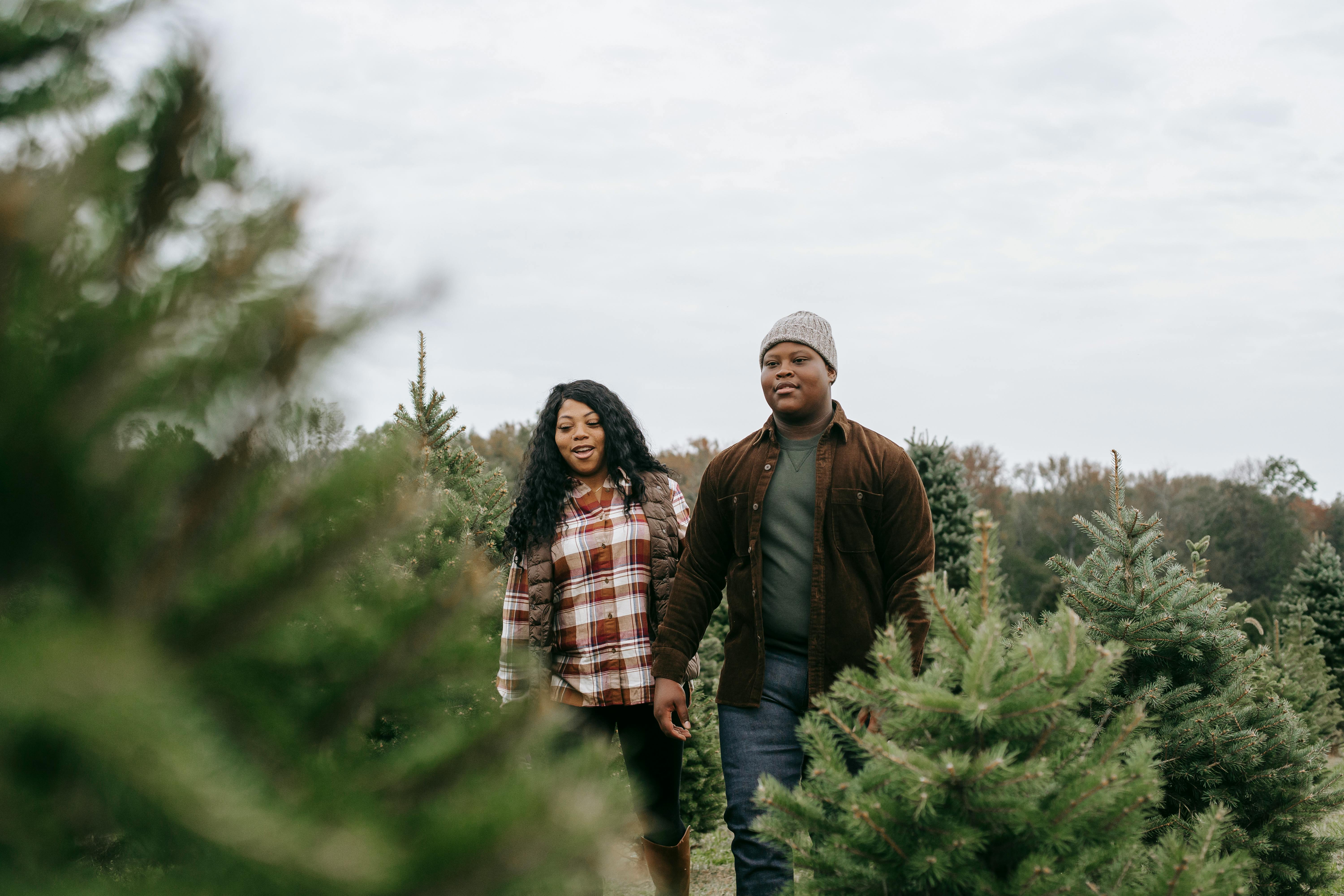 positive black mother and son walking between trees