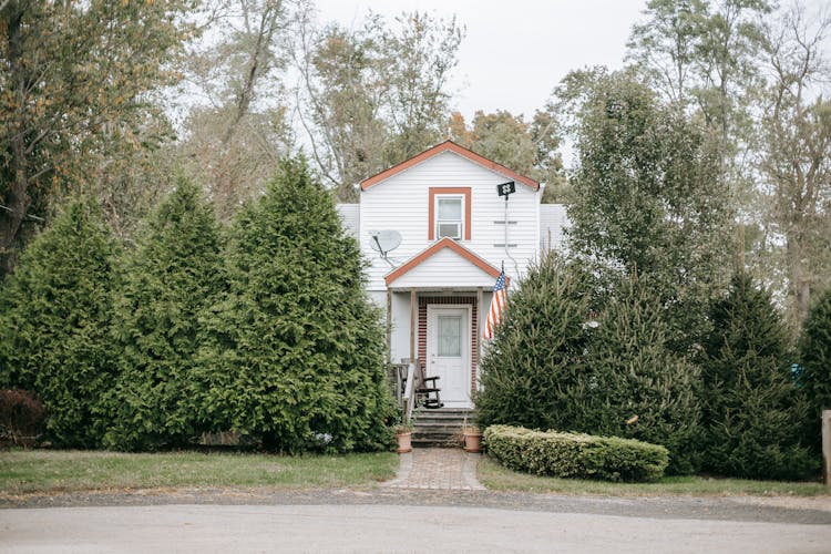 Wooden House With American Flag In Countryside