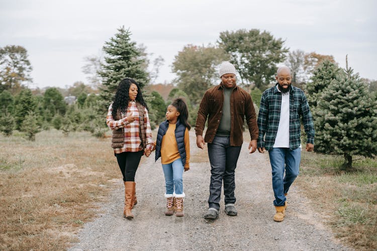 African American Walking On Footpath In Farm With Fir Trees