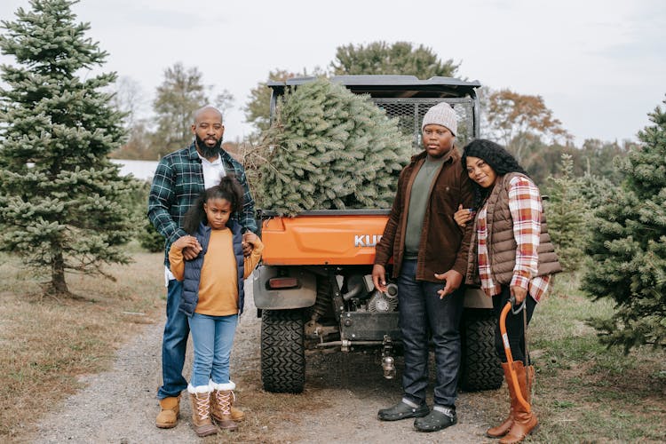 Positive Black Family Near Car With Fir