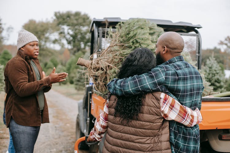 Unrecognizable Black Parents Interacting With Son Near ATV On Farm