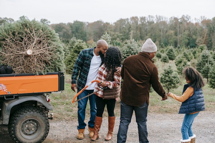 Anonymous African American Family On Road Near Fir Trees