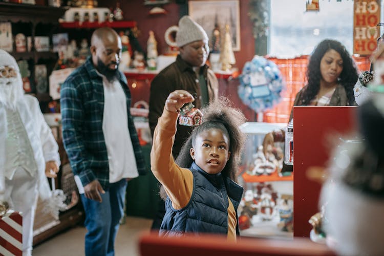 Black Family Choosing Christmas Souvenirs In Shop