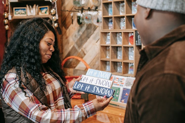 Cheerful Black Woman Near Crop Man In Souvenir Shop