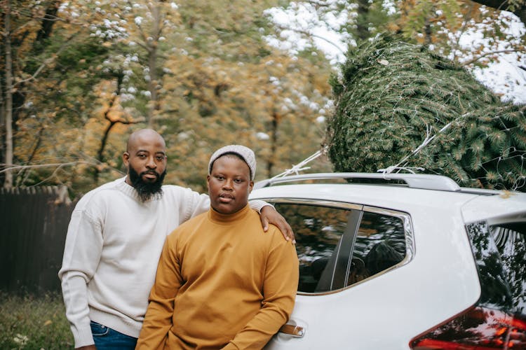 Black Hipster Man Embracing Son Near Auto With Spruce