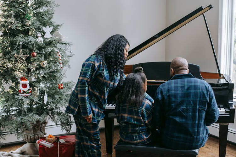 Black Family Playing Piano In Cozy Room With Christmas Tree